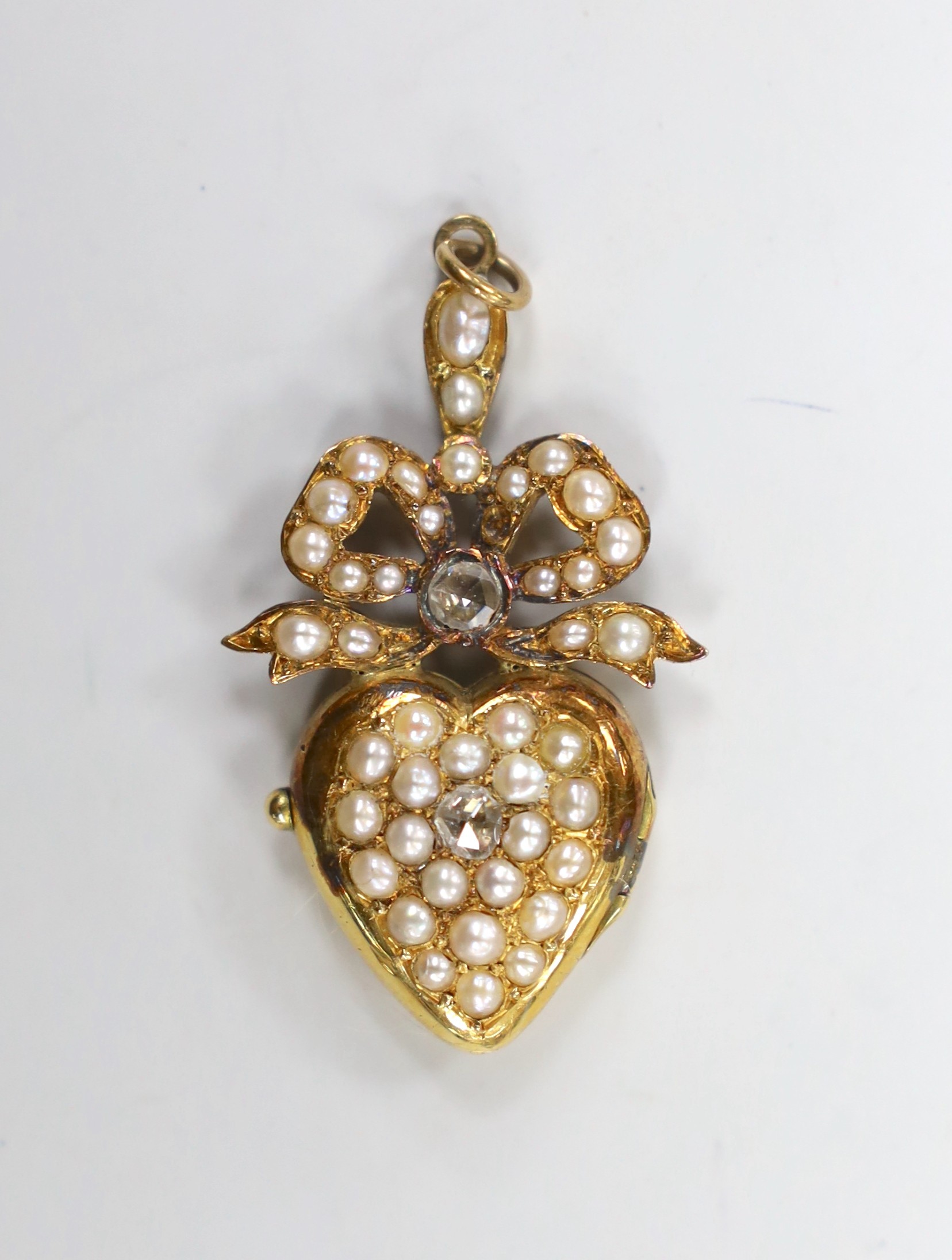 An Edwardian yellow metal, rose cut diamond and split pearl cluster set heart shaped locket pendant, containing a lock of hair, overall 40mm, gross weight 9.2 grams (pearl missing).